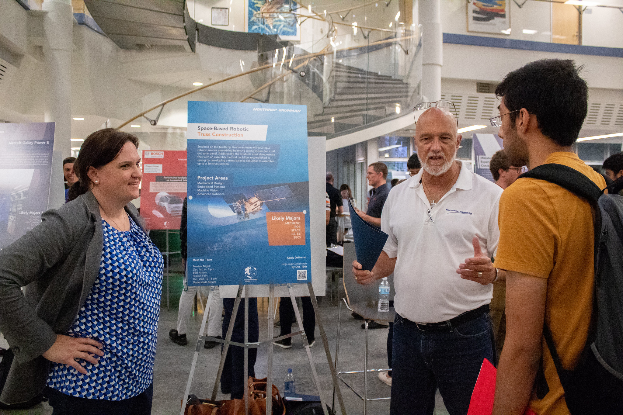Two Northrop Grumman representatives talking to a prospective candidate.