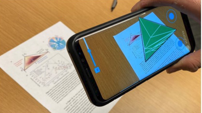 View of a phone with 3D visualization of graph with 2D paper worksheet in background