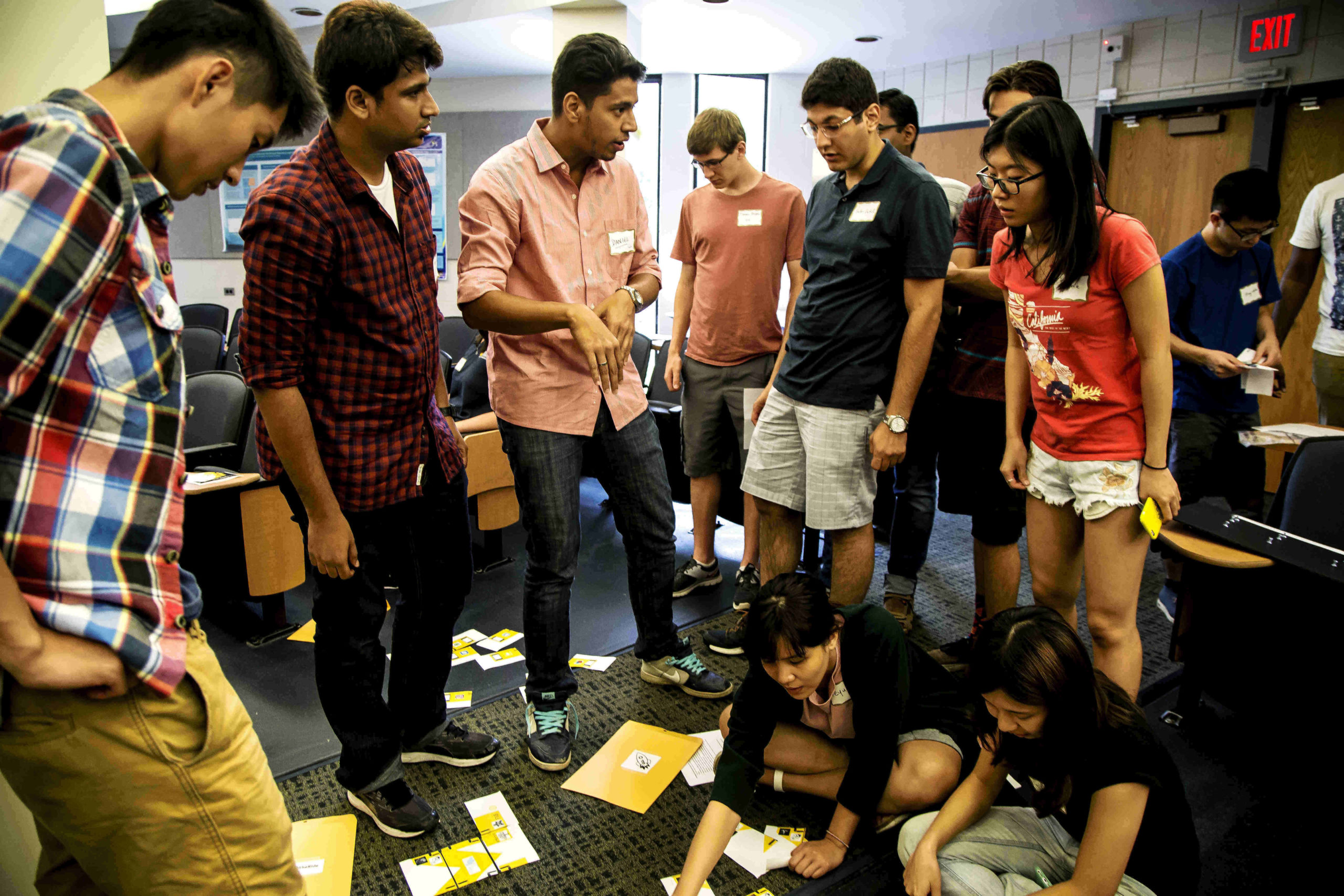 Students standing and kneeling to work on a team-building activity