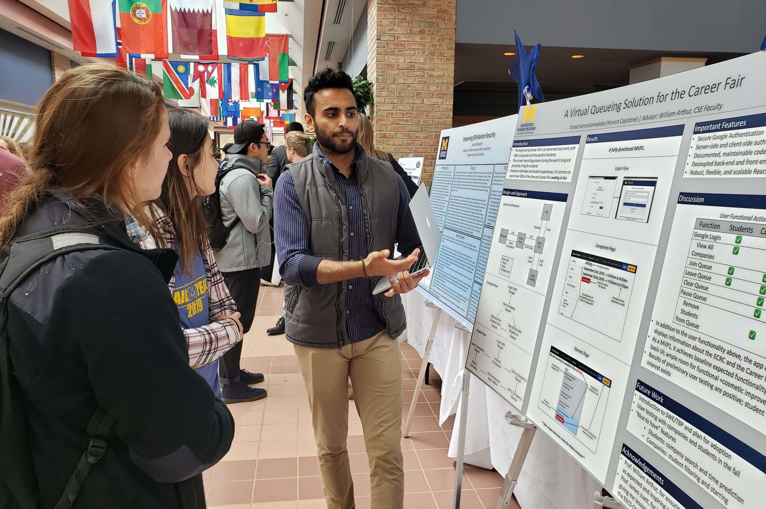 A student listening to a speech at a poster presentation in Pierpont Commons