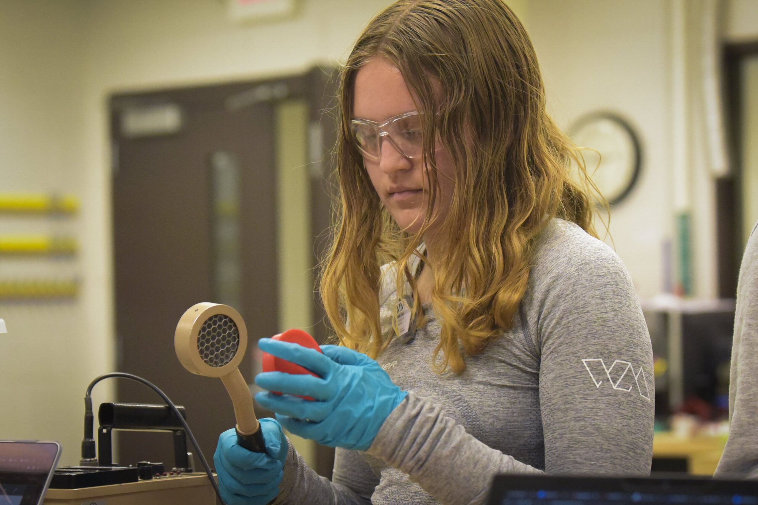 Student holding detector measuring radiation from sample