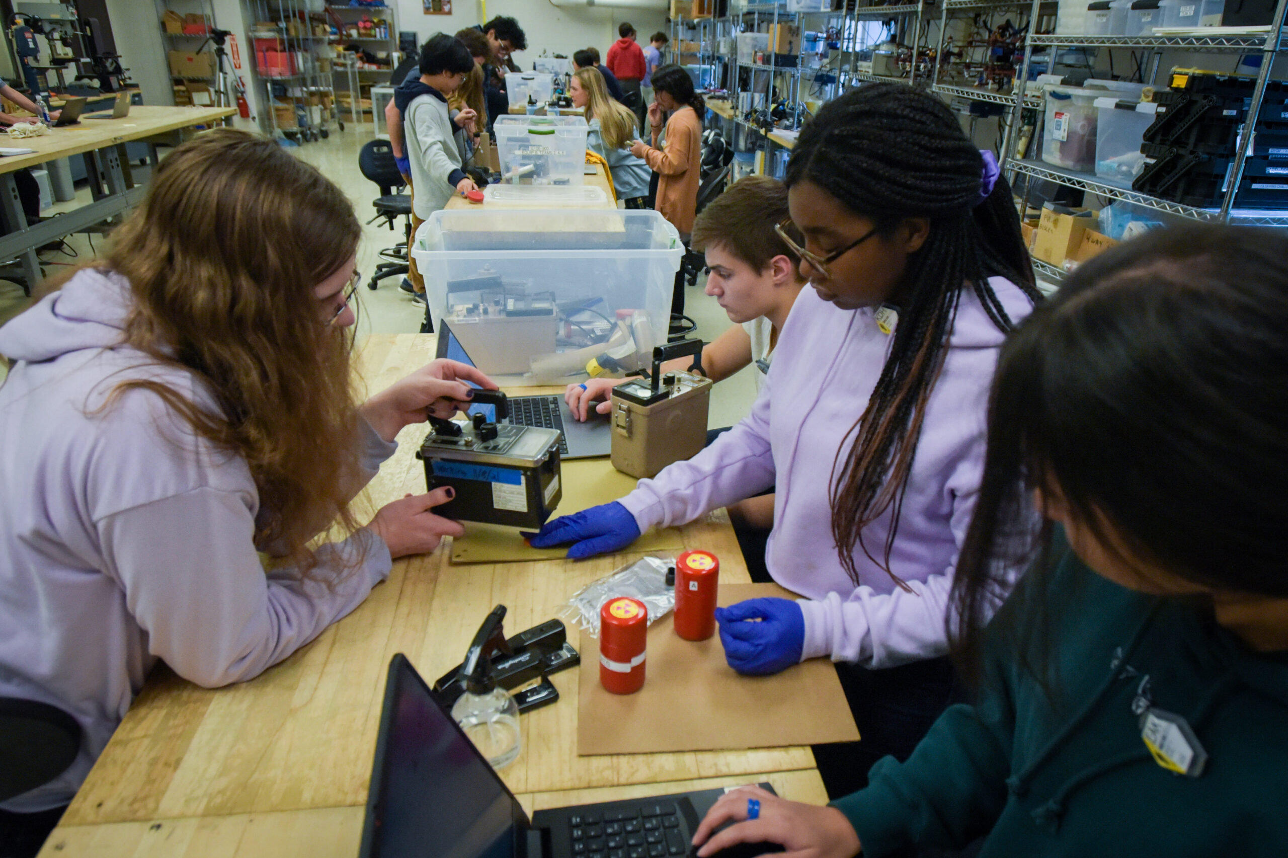 Group of students working with Geiger Counter at workbench