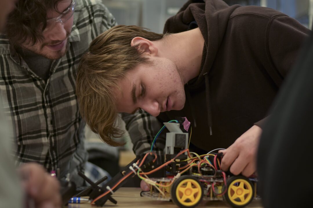 student fixing wiring on robot car