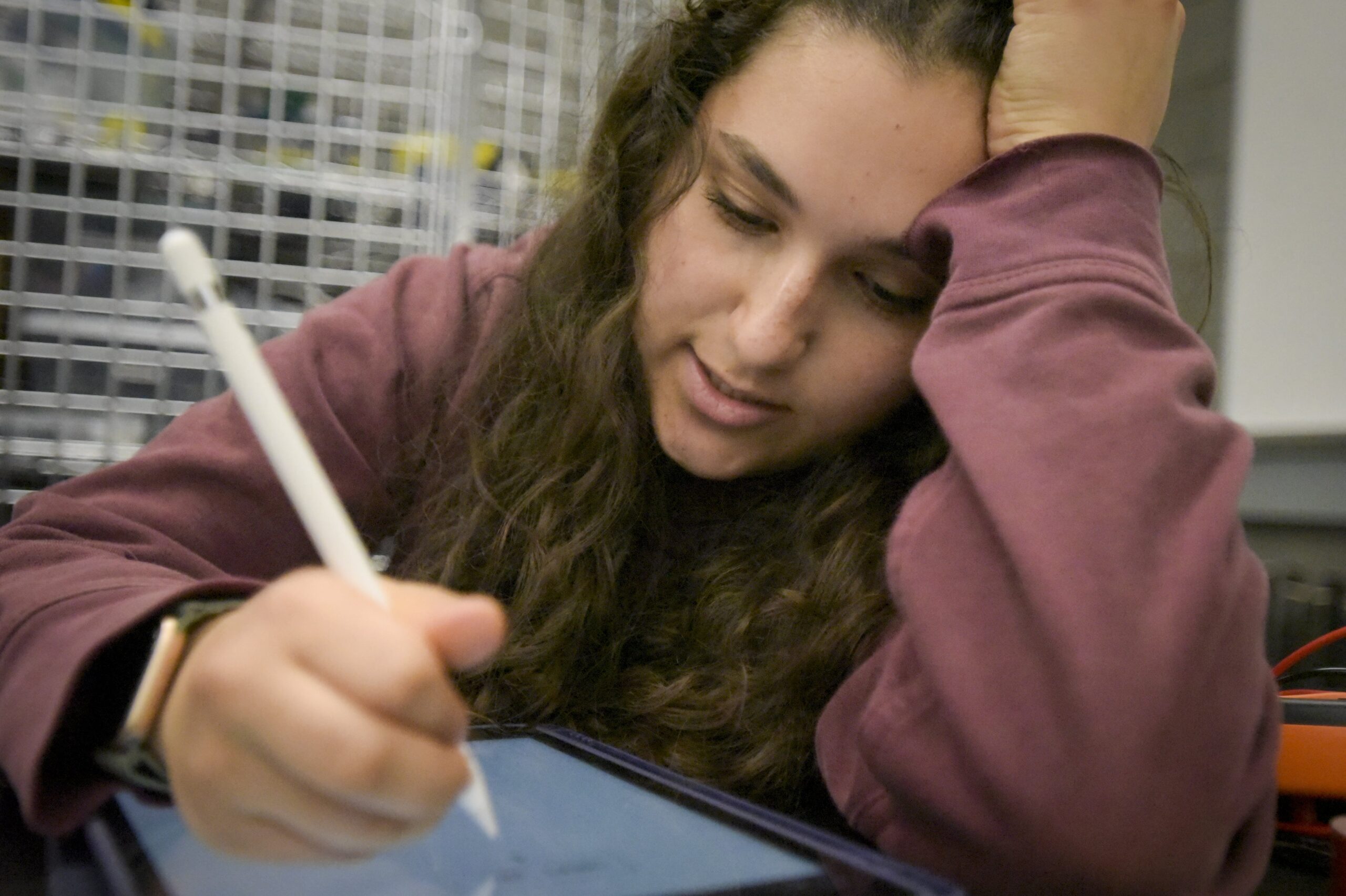Student working, writing on iPad